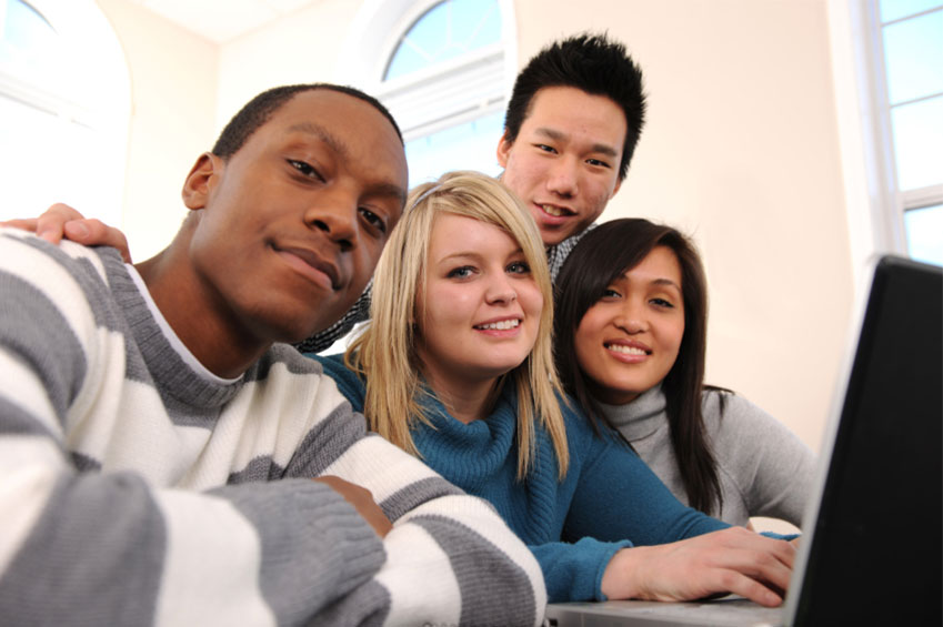 Diverse group of high school students around computer